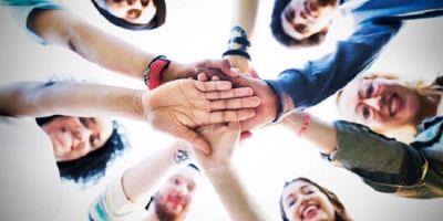 Young workers puttheir hands together