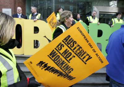 A worker holds a placard protesting against austerity